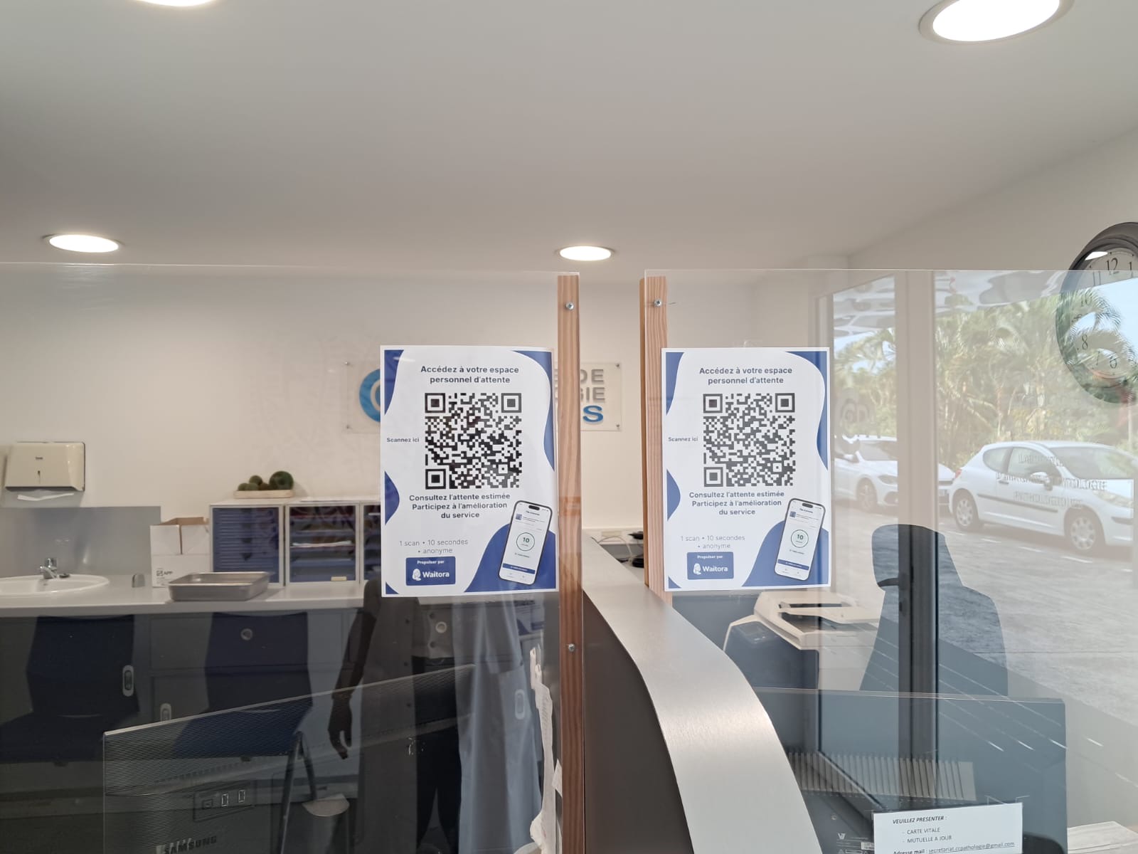 Affiches QR code Waitora au guichet d'accueil derrière une vitre